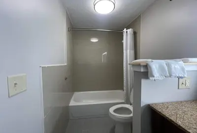 a bathroom with a toilet and a shower and a sink at Days Inn & Suites by Wyndham York in York
