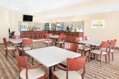 a restaurant with tables and chairs and a counter at Days Inn & Suites by Wyndham York in York