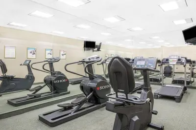 a gym with several treadmills and elliptical machines at Days Inn & Suites by Wyndham York in York