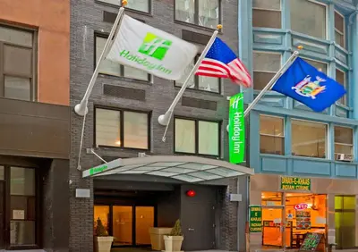 two flags are flying outside of a building at Holiday Inn New York City - Wall Street by IHG in New York