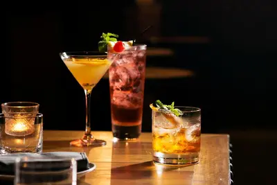 three cocktails sitting on a wooden table at Holiday Inn New York City - Wall Street by IHG in New York