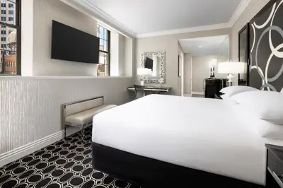 a hotel room with a large bed and a television at The Muse New York in New York