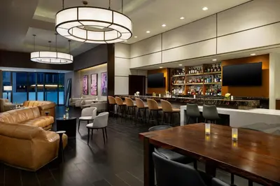a restaurant with a bar and tables and chairs at The Muse New York in New York