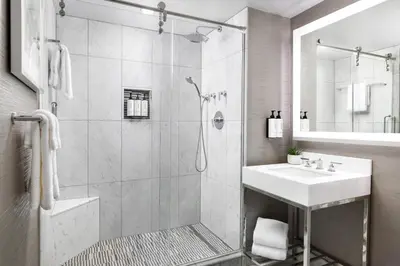 a white bathroom with a shower and a sink at The Muse New York in New York