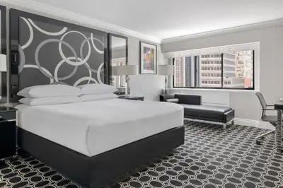 a bedroom with a large bed and a living room at The Muse New York in New York