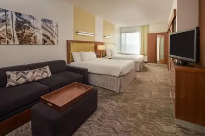 a hotel room with a couch and a bed and a tv at SpringHill Suites by Marriott Philadelphia Airport / Ridley Park in Ridley Park
