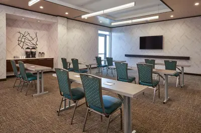 a conference room with tables and chairs and a tv at SpringHill Suites by Marriott Philadelphia Airport / Ridley Park in Ridley Park
