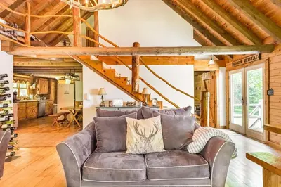 a living room with a couch and a staircase at Roscoe Retreat in Roscoe