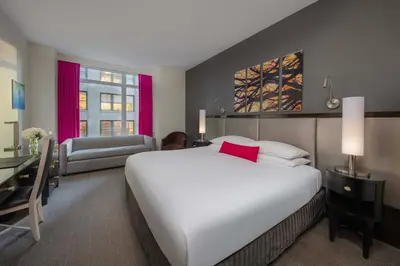 a bedroom with a large white bed and a desk at Royalton Park Avenue in New York