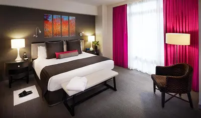 a bedroom with a large bed with red curtains at Royalton Park Avenue in New York