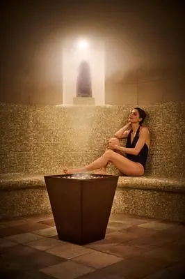 a woman sitting on a wall talking on a cell phone at Mandarin Oriental, New York in New York