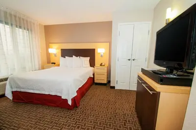 a hotel room with a bed and a flat screen tv at TownePlace Suites by Marriott Scranton Wilkes-Barre in Moosic