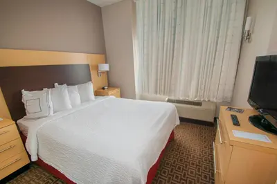 a hotel room with a bed and a flat screen tv at TownePlace Suites by Marriott Scranton Wilkes-Barre in Moosic