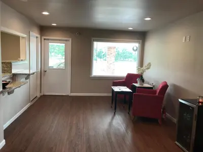a living room with two red chairs and a table at Blue Note Motor Inn in Marietta