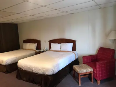 a hotel room with two beds and a red chair at Blue Note Motor Inn in Marietta