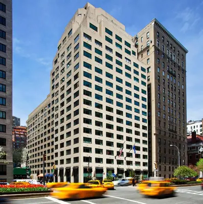 a tall white building with taxis in front of it at Loews Regency New York Hotel in New York