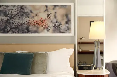a bedroom with a bed and a painting on the wall at Loews Regency New York Hotel in New York