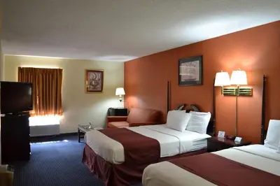 a hotel room with two beds and a television at Red Carpet Inn Newark - Irvington NJ in Irvington