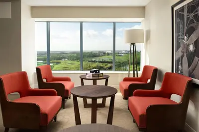 a waiting room with chairs and a table and a large window at Delta Hotels by Marriott Philadelphia Airport in Philadelphia