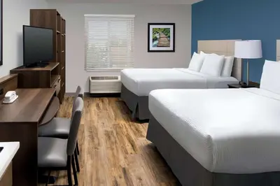 a hotel room with two beds and a desk at WoodSpring Suites South Plainfield in South Plainfield