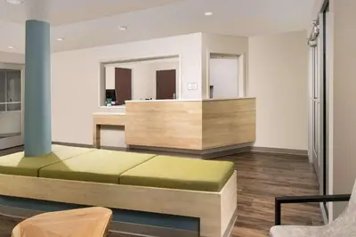 a living room with a couch and a mirror at WoodSpring Suites South Plainfield in South Plainfield