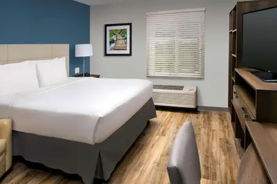 a hotel room with a large bed and a television at WoodSpring Suites South Plainfield in South Plainfield