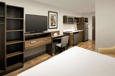 a hotel room with a bed and a desk with a television at WoodSpring Suites South Plainfield in South Plainfield