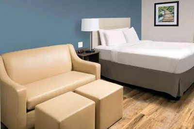 a hotel room with a bed and a chair at WoodSpring Suites South Plainfield in South Plainfield