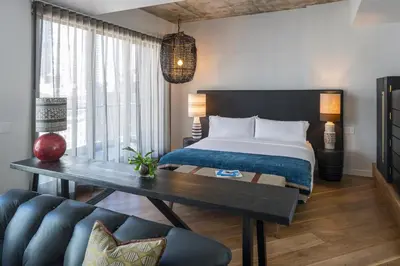 a bedroom with a bed and a table and a couch at MADE Hotel in New York