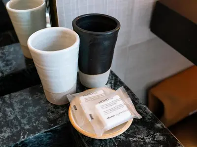a table with three vases and a box on it at MADE Hotel in New York