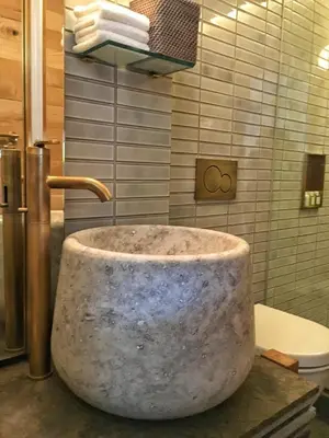 a marble sink in a bathroom with a toilet at MADE Hotel in New York