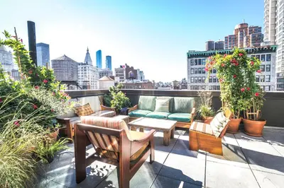 a balcony with couches and chairs on a building at MADE Hotel in New York
