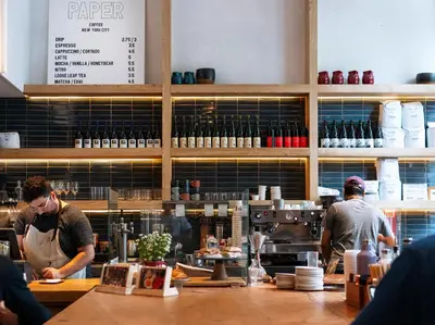 two men standing behind a counter in a kitchen at MADE Hotel in New York