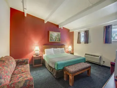 a hotel room with a bed and a couch at Red Carpet INN Whippany in Whippany