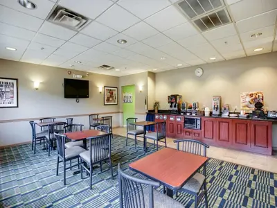 a restaurant with tables and chairs and a kitchen at Red Carpet INN Whippany in Whippany