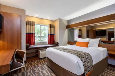a hotel room with a bed and a desk at Microtel Inn & Suites by Wyndham Philadelphia Airport in Philadelphia