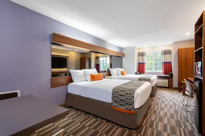a hotel room with two beds and a television at Microtel Inn & Suites by Wyndham Philadelphia Airport in Philadelphia