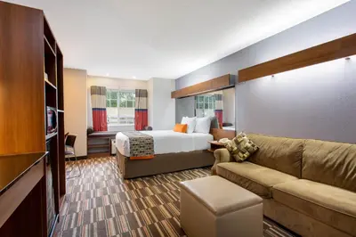 a hotel room with a bed and a couch at Microtel Inn & Suites by Wyndham Philadelphia Airport in Philadelphia