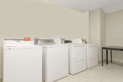 a laundry room with white appliances and a table at Microtel Inn & Suites by Wyndham Philadelphia Airport in Philadelphia