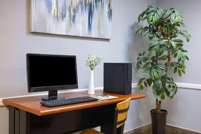 a desk with a computer and a plant on it at Super 8 by Wyndham Mount Laurel in Mount Laurel