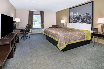 a hotel room with a bed and a flat screen tv at Super 8 by Wyndham Mount Laurel in Mount Laurel