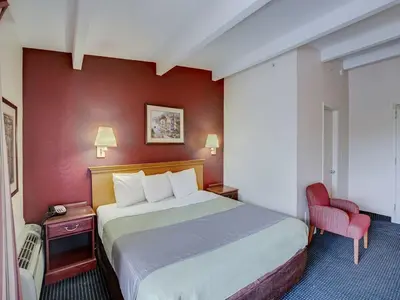 a hotel room with a bed and a red wall at Scottish Inn Whippany in Whippany