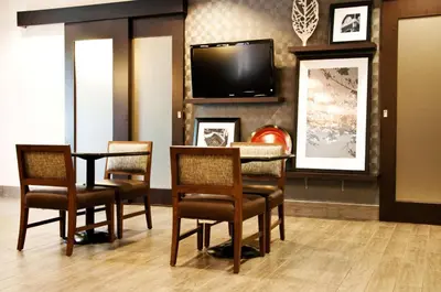 a dining room with a table and chairs and a tv at Hampton Inn Doylestown in Warrington