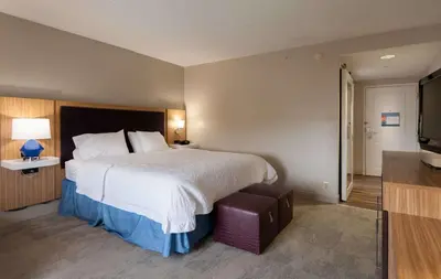 a hotel room with a bed and a flat screen tv at Hampton Inn Doylestown in Warrington