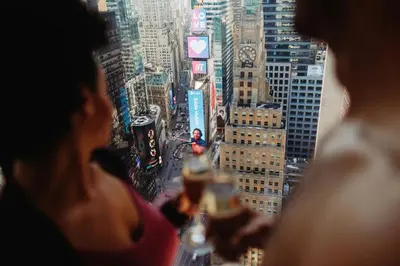 a group of people looking out of a window at a city at New York Marriott Marquis in New York