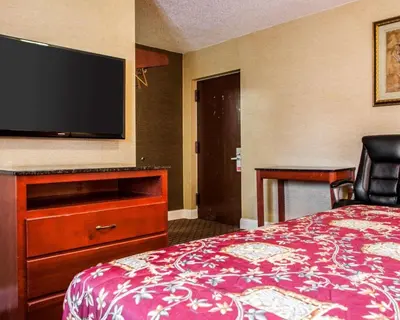 a hotel room with a bed and a flat screen tv at Rodeway Inn Paterson Great Falls Park Area in Paterson