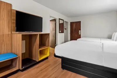a hotel room with a bed and a flat screen tv at Days Inn by Wyndham Lancaster PA Dutch Country in Ronks