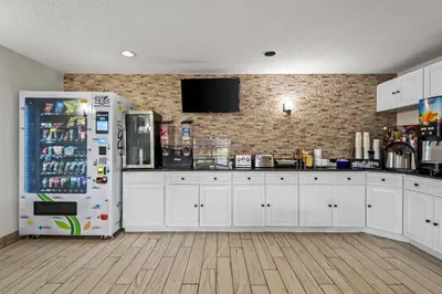 a kitchen with white cabinets and a refrigerator at Days Inn by Wyndham Lancaster PA Dutch Country in Ronks