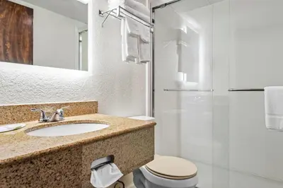 a bathroom with a sink and a toilet and a shower at Days Inn by Wyndham Lancaster PA Dutch Country in Ronks
