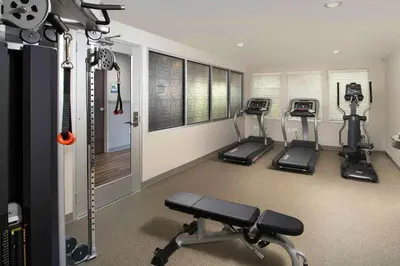 a gym with three treadmills in a room at Woodspring Suites Cherry Hill in Cherry Hill